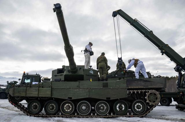 Technicians from a mobile Forward Repair System NATO (FRSN), a deployable repair workshop, remove the motor from a Leopard 2 A4 tank of the Norwegian army during a demonstration near Setermoen on March 12, 2026, as NATO conducts its Cold Response military exercise. The Norwegian-led winter exercise involves 32.000 troops, 100 aircraft, and 30 warships from 14 nations taking part in high intensity, multi-domain operations in an arctic climate. (Photo by John MACDOUGALL / AFP)