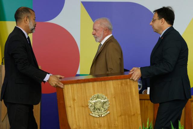 Brazil's President Luiz Inacio Lula da Silva (C) leaves after signing new measures aimed at mitigating the impact of high oil prices on diesel costsat the Planalto Palace in Brasilia, on March 12, 2026. (Photo by Sergio Lima / AFP)