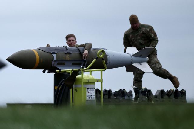 USAF military ground personnel prepare a Joint Direct Attack Munition (JDAM) for a US Air Force (USAF) B-1 Lancer bomber jet on the tarmac at RAF Fairford in south-west England on March 12, 2026. Fairford is one of two bases, along with the Diego Garcia facility in the Indian Ocean, that the UK has given the US permission to use for "specific defensive operations into Iran" to destroy Iranian missiles at source, the British defence minister said in a statement. (Photo by Henry NICHOLLS / AFP)