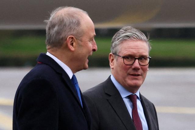 Britain's Prime Minister Keir Starmer is welcomed by Ireland's Prime Minister Michael Martin upon his arrival at Cork Airport in Cork, Ireland, on March 12, 2026, for a two-day UK-Ireland summit. (Photo by Cathal McNaughton / POOL / AFP)