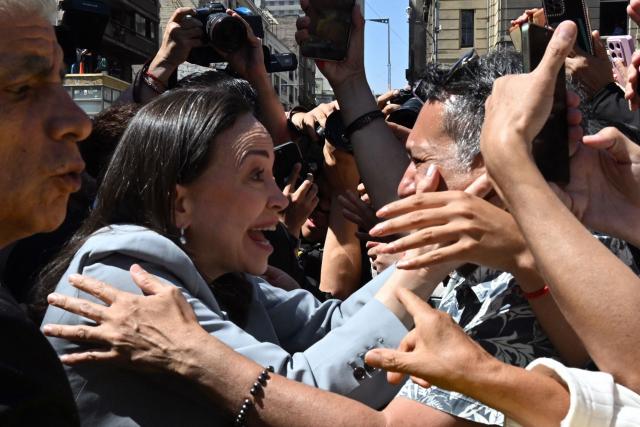 TOPSHOT - Venezuelan opposition leader Maria Corina Machado greets members of the Venezuelan community after receiving the key to the city in Santiago on March 12, 2026. Machado travelled to Chile to attend Chile's President Jose Antonio Kast's inauguration. (Photo by RODRIGO ARANGUA / AFP)