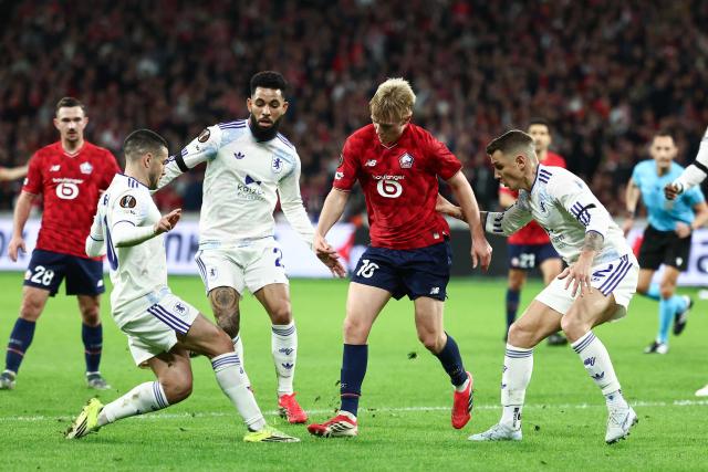 Aston Villa's Argentinian midfielder #10 Emiliano Buendia (L), Aston Villa's Brazilian midfielder #21 Douglas Luiz (2L) and Aston Villa's French defender #12 Lucas Digne fight for the ball with Lille's Icelandic midfielder #10 Hakon Arnar Haraldsson (2R) during the UEFA Europa League round of 16 first leg football match between Lille (LOSC) and Aston Villa  at the Pierre-Mauroy Stadium in Villeneuve-d'Ascq, northern France, on March 12, 2026. (Photo by Sameer AL-DOUMY / AFP)