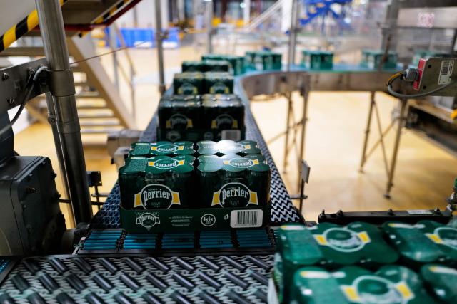 This photograph shows cans packages on the production line of Perrier's sparkling mineral water factory in Vergeze, southern France, on March 12, 2026. (Photo by Sylvain THOMAS / AFP)