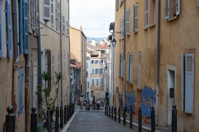 People walk in a street in the le Panier district of Marseille, southern France, on March 11, 2026. (Photo by Elodie CLEMENT / AFP)
