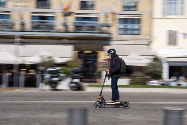 A man rides an electric scooter in the old harbor Marseille, southern France, on March 12, 2026. (Photo by Elodie CLEMENT / AFP)