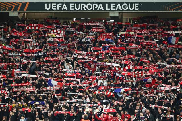 Lille's supporters hold scarfs on the stands during the UEFA Europa League round of 16 first leg football match between Lille (LOSC) and Aston Villa  at the Pierre-Mauroy Stadium in Villeneuve-d'Ascq, northern France, on March 12, 2026. (Photo by Sameer AL-DOUMY / AFP)