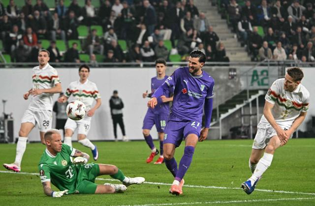 Ferencvaros' Hungarian goalkeeper #99 David Grof (L) makes a save during the UEFA Europa League - Last 16 - first leg football match Ferencvaros v Sporting Braga in Budapest, Hungary, on March 12, 2026. (Photo by Attila KISBENEDEK / AFP)