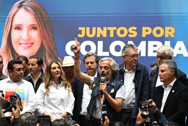 Colombia's vice-presidential candidate for the conservative Democratic Centre party, Juan Daniel Oviedo (C), gives a speech next to presidential candidate Paloma Valencia (2nd-L) during his presentation as running mate in Bogota on March 12, 2026. Colombia will hold presidential elections on May 31st. (Photo by Raul ARBOLEDA / AFP)