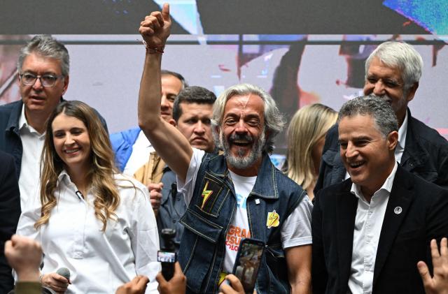 Colombia's vice-presidential candidate for the conservative Democratic Centre party, Juan Daniel Oviedo (C), gestures next to presidential candidate Paloma Valencia (L) during his presentation as running mate in Bogota on March 12, 2026. Colombia will hold presidential elections on May 31st. (Photo by Raul ARBOLEDA / AFP)