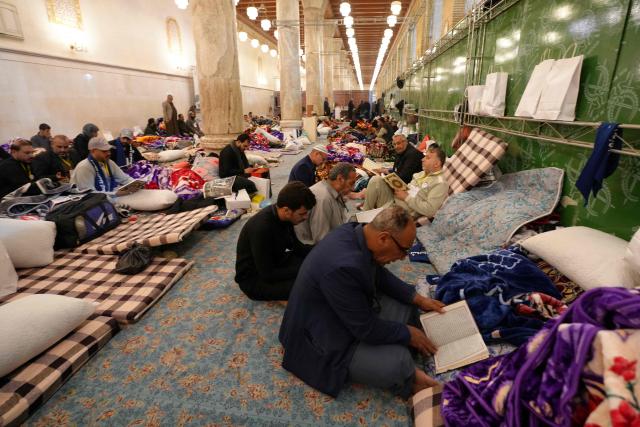 Shia Muslim faithful, including Iranian visitors and others, participate in the ritual of Itikaf, or spiritual retreat, at the Kufa Mosque, taking advantage of the days and nights of Laylat al-Qadr, or the Night of Destiny, one of the holiest nights during the fasting month of Ramadan, to pray in the holy city of Kufa, south of the Iraqi capital Baghdad, on March 12, 2026. (Photo by Qassem al-KAABI / AFP)