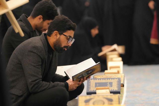 A Shia Muslim faithful recites from a copy of the Koran, Islam's holy book, as he participates in the ritual of Itikaf, or spiritual retreat, at the Kufa Mosque, taking advantage of the days and nights of Laylat al-Qadr, or the Night of Destiny, one of the holiest nights during the fasting month of Ramadan, to pray in the holy city of Kufa, south of the Iraqi capital Baghdad on March 12, 2026. (Photo by AFP)