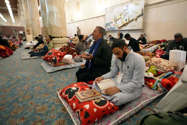 Shia Muslim faithful, including Iranian visitors and others, participate in the ritual of Itikaf, or spiritual retreat, at the Kufa Mosque, taking advantage of the days and nights of Laylat al-Qadr, or the Night of Destiny, one of the holiest nights during the fasting month of Ramadan, to pray in the holy city of Kufa, south of the Iraqi capital Baghdad, on March 12, 2026. (Photo by Qassem al-KAABI / AFP)