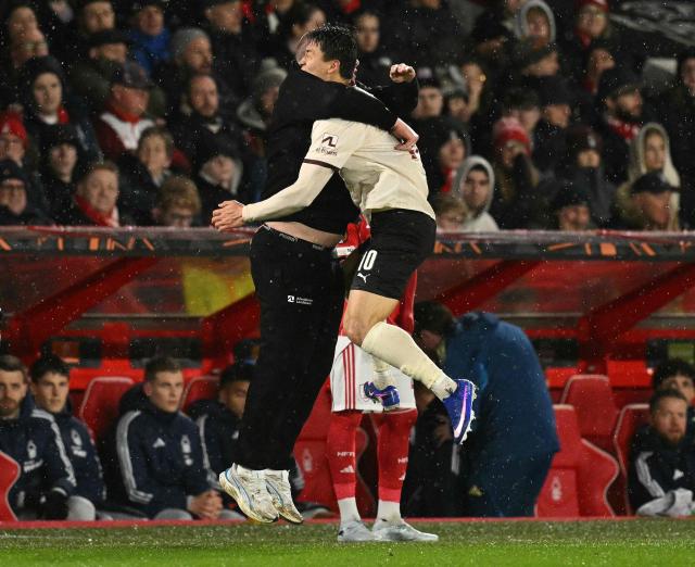 Midtjylland's South Korean forward #10 Gue-sung Cho (R) celebrates scoring the opening goal with Midtjylland's Danish coach Mike Tullberg during the UEFA Europa League round of 16, first leg football match between Nottingham Forest and FC Midtjylland at The City Ground in Nottingham, central England, on March 12, 2026. (Photo by Oli SCARFF / AFP)