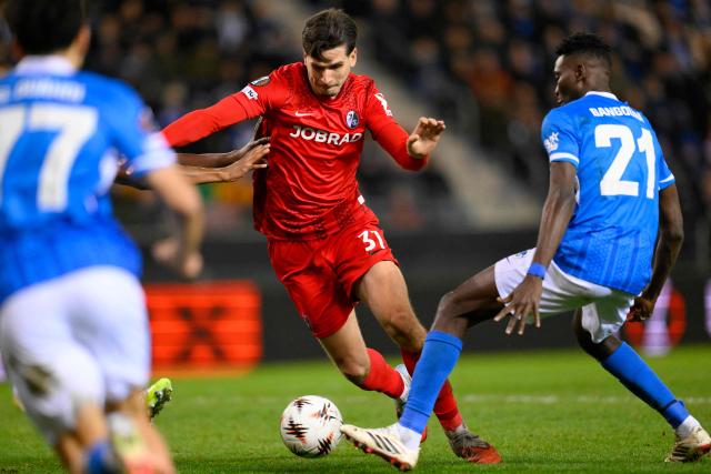 SC Freiburg's Croatian forward #31 Igor Matanovic (C) and Genk's Guinean midfielder #21 Ibrahima Sory Bangoura (R) fight for the ball during the UEFA Europa League last 16 first leg football match between KRC Genk and SC Freiburg at the Fenix Stadium in Genk on March 12, 2026. (Photo by JOHN THYS / AFP)