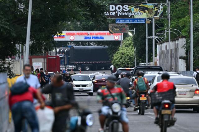 Vehicles cross the Colombia-Venezuela border towards the Venezuelan Main Customs Office in San Antonio del Tachira, taken from the Simon Bolivar International Bridge on the outskirts of Cucuta, Colombia on March 12, 2026. The first foreign visit of Venezuela's US-backed interim leader, Delcy Rodriguez, since taking power was abruptly cancelled on March 12, 2026, just hours before she was due to arrive in Colombia, a Colombian foreign ministry source told AFP. (Photo by Luis ACOSTA / AFP)