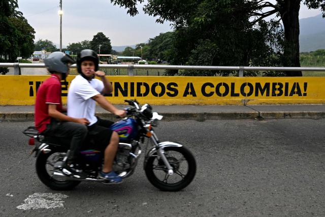 A man riding a motorbike gestures as he crosses the Colombia-Venezuela border at the Simon Bolivar International Bridge on the outskirts of Cucuta, Colombia on March 12, 2026. The first foreign visit of Venezuela's US-backed interim leader, Delcy Rodriguez, since taking power was abruptly cancelled on March 12, 2026, just hours before she was due to arrive in Colombia, a Colombian foreign ministry source told AFP. (Photo by Luis ACOSTA / AFP)