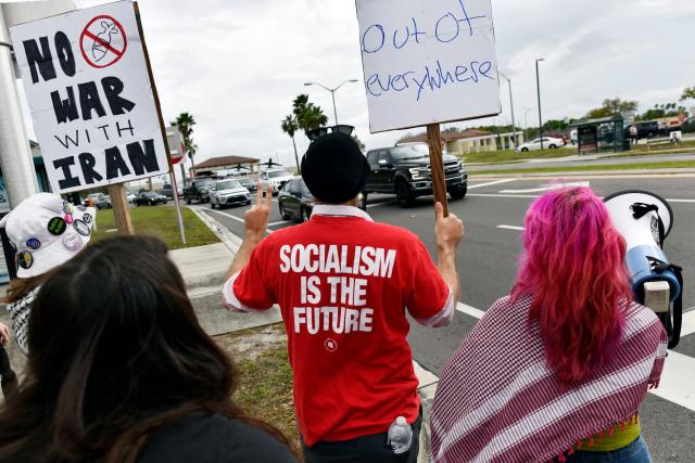 Demonstrators hold signs during a protest to call for "an end to the imperialist violence" amid the ongoing war in Iran outside MacDill Air Force Base, where US Central Command is headquartered, in Tampa, Florida, on March 12, 2026. (Photo by Octavio JONES / AFP)