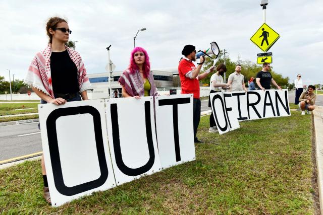 Demonstrators hold a large sign during a protest to call for "an end to the imperialist violence" amid the ongoing war in Iran outside MacDill Air Force Base, where US Central Command is headquartered, in Tampa, Florida, on March 12, 2026. (Photo by Octavio JONES / AFP)