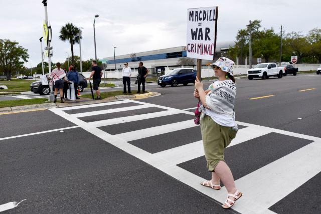 A demonstrator holds a sign during a protest to call for "an end to the imperialist violence" amid the ongoing war in Iran outside MacDill Air Force Base, where US Central Command is headquartered, in Tampa, Florida, on March 12, 2026. (Photo by Octavio JONES / AFP)