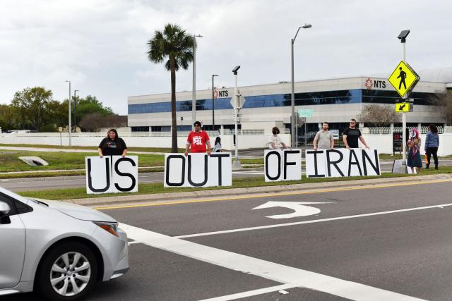 Demonstrators hold a large sign during a protest to call for "an end to the imperialist violence" amid the ongoing war in Iran outside MacDill Air Force Base, where US Central Command is headquartered, in Tampa, Florida, on March 12, 2026. (Photo by Octavio JONES / AFP)