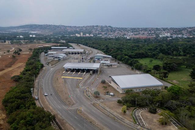 This aerial view shows the entrance of the Atanasio Girardot International Bridge on the Colombia-Venezuela border, where a stage was dismantled for an encounter between Colombia's President Gustavo Petro and Venezuela's interim President Delcy Rodriguez on the outskirts of Cucuta, Colombia, on March 12, 2026. The first foreign visit of Venezuela's US-backed interim leader, Delcy Rodriguez, since taking power was abruptly cancelled on March 12, 2026, just hours before she was due to arrive in Colombia, a Colombian foreign ministry source told AFP. (Photo by Luis ACOSTA / AFP)