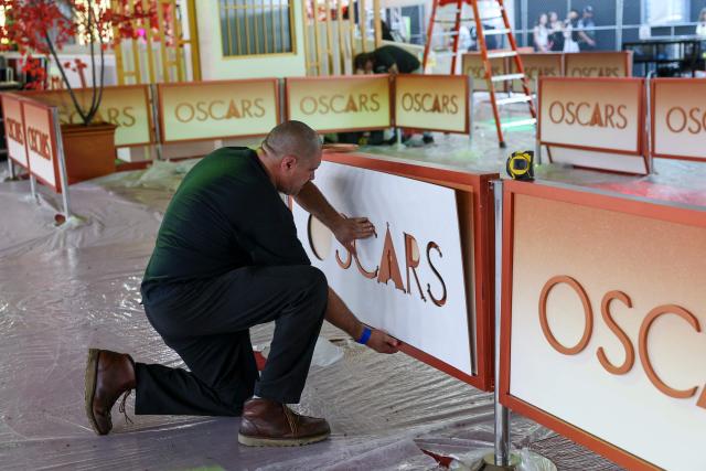 A worker installs a backdrop panel as preparations are made on the carpet arrivals area ahead of the 98th Annual Academy Awards outside the Dolby Theatre in Hollywood, California, on March 12, 2026. (Photo by ANGELA WEISS / AFP)