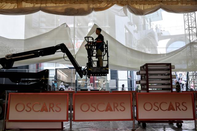 A worker rides a lift as preparations are made on the carpet arrivals area ahead of the 98th Annual Academy Awards outside the Dolby Theatre in Hollywood, California, on March 12, 2026. (Photo by ANGELA WEISS / AFP)