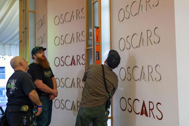 Workers install backdrop panels as preparations are made on the carpet arrivals area ahead of the 98th Annual Academy Awards outside the Dolby Theatre in Hollywood, California, on March 12, 2026. (Photo by ANGELA WEISS / AFP)