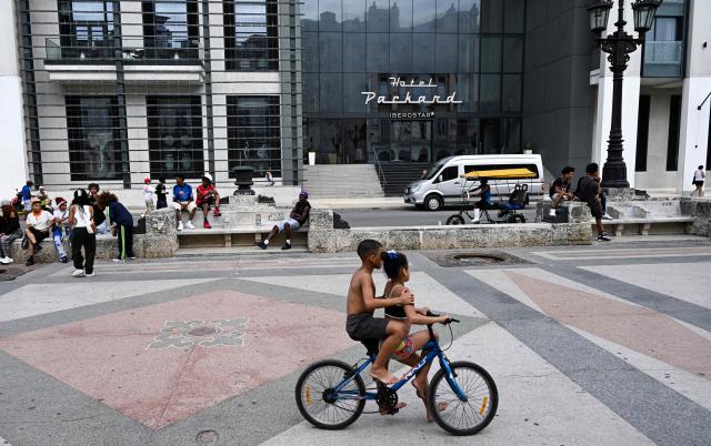 People spend time in the public area in front of the Iberostar Grand Packard Hotel in Havana on March 12, 2026. (Photo by YAMIL LAGE / AFP)
