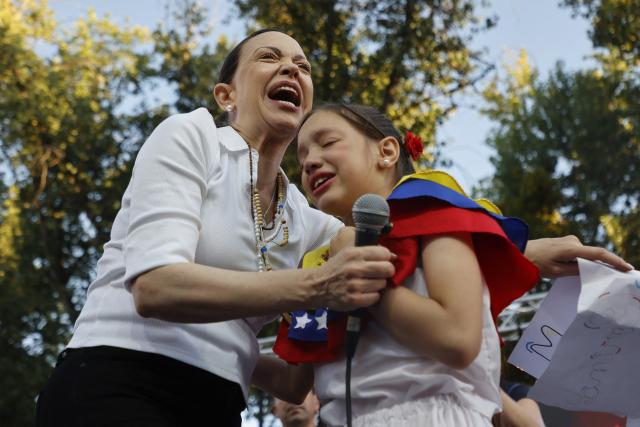 Venezuelan opposition leader Maria Corina Machado embraces a girl during an encounter with members of the Venezuelan community in Chile at Almagro Square in Santiago on March 12, 2026. Machado travelled to Chile to attend Chile's President Jose Antonio Kast's inauguration. (Photo by Raul BRAVO / AFP)