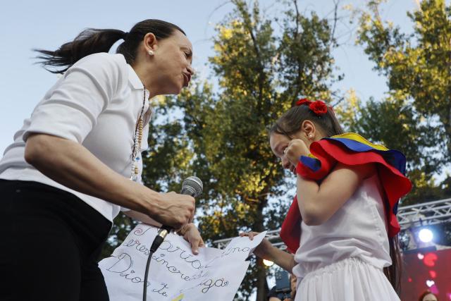 Venezuelan opposition leader Maria Corina Machado talks with a girl crying during an encounter with members of the Venezuelan community in Chile at Almagro Square in Santiago on March 12, 2026. Machado travelled to Chile to attend Chile's President Jose Antonio Kast's inauguration. (Photo by Raul BRAVO / AFP)