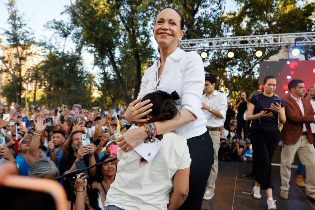 Venezuelan opposition leader Maria Corina Machado embraces a girl during an encounter with members of the Venezuelan community in Chile at Almagro Square in Santiago on March 12, 2026. Machado travelled to Chile to attend Chile's President Jose Antonio Kast's inauguration. (Photo by Raul BRAVO / AFP)