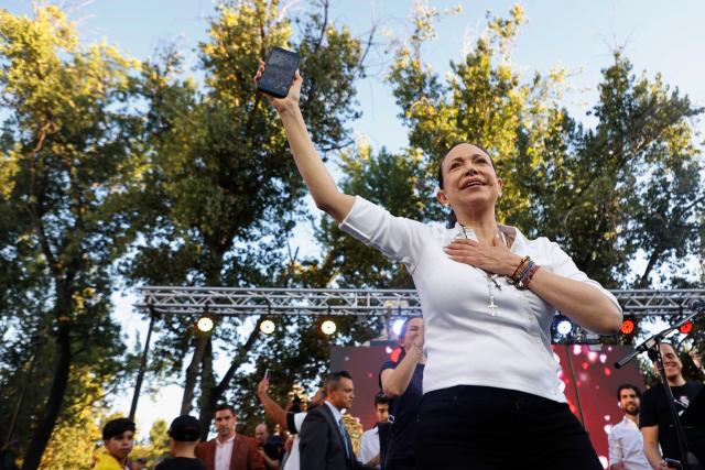 Venezuelan opposition leader Maria Corina Machado films the crowd with her phone during an encounter with members of the Venezuelan community in Chile at Almagro Square in Santiago on March 12, 2026. Machado travelled to Chile to attend Chile's President Jose Antonio Kast's inauguration. (Photo by Raul BRAVO / AFP)