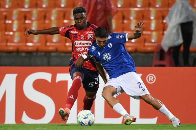 Independiente Medellin's forward #20 John Montano (L) and Juventud's defender #24 Federico Barrandeguy fight for the ball during the Copa Libertadores phase three second-leg football match between Colombia's Independiente Medellin and Uruguay's Juventud at the Atanasio Girardot Stadium in Medellin, Colombia on March 12, 2026. (Photo by Jaime SALDARRIAGA / AFP)