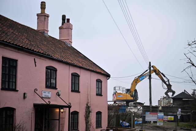 This photo taken on February 3, 2026 shows a general view of the demolition of a property on the coastline of Thorpeness, Suffolk. In an English seaside village, researchers discuss options for relocating a graveyard threatened with slipping into the sea, or moving back a car park perilously close to a cliff edge. The team from the Coastwise project have been granted over 15 million pounds (20 million USD) in government funding to adapt the coastline in North Norfolk, eastern England, to accelerating erosion worsened by climate change. (Photo by Ben STANSALL / AFP) / TO GO WITH Britain-climate-environment,FOCUS by Akshata KAPOOR