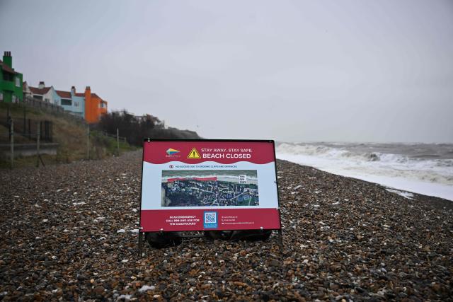 This photo taken on February 3, 2026 shows a general view of a sign informing of a closed area of beach on the coastline of Thorpeness, Suffolk. In an English seaside village, researchers discuss options for relocating a graveyard threatened with slipping into the sea, or moving back a car park perilously close to a cliff edge. The team from the Coastwise project have been granted over 15 million pounds (20 million USD) in government funding to adapt the coastline in North Norfolk, eastern England, to accelerating erosion worsened by climate change. (Photo by Ben STANSALL / AFP) / TO GO WITH Britain-climate-environment,FOCUS by Akshata KAPOOR