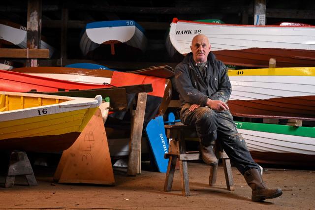 This photo taken on February 3, 2026 shows Thoroeness resident and boatyard owner Craig Block posing for a photograph in Thorpeness, Suffolk. In an English seaside village, researchers discuss options for relocating a graveyard threatened with slipping into the sea, or moving back a car park perilously close to a cliff edge. The team from the Coastwise project have been granted over 15 million pounds (20 million USD) in government funding to adapt the coastline in North Norfolk, eastern England, to accelerating erosion worsened by climate change. (Photo by Ben STANSALL / AFP) / TO GO WITH Britain-climate-environment,FOCUS by Akshata KAPOOR