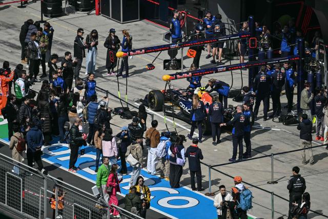 Mechanics work on the car of Red Bull Racing's French driver Isack Hadjar before a practice session ahead of the Formula One Chinese Grand Prix at the Shanghai International Circuit in Shanghai on March 13, 2026. (Photo by HECTOR RETAMAL / AFP)