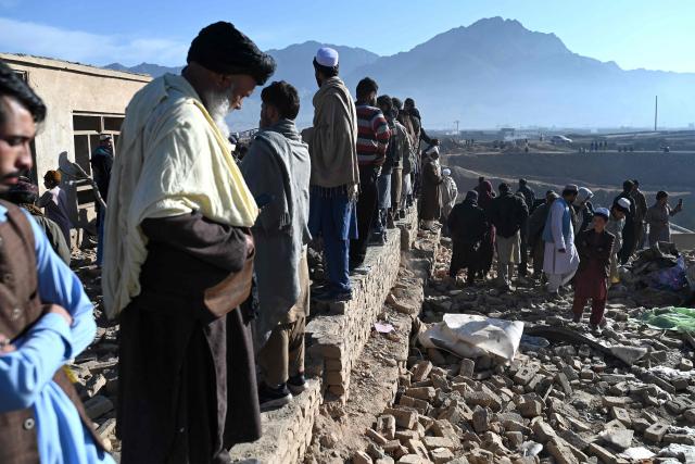 Afghan residents stand amidst damaged houses at the site of an overnight Pakistan airstrike, at a residential area in Pol-e-Charkhi on the outskirts of Kabul on March 13, 2026. Afghan authorities said on March 13 that Pakistan had carried out new strikes on Kabul and border provinces, killing four people in the capital. (Photo by Wakil Kohsar / AFP)