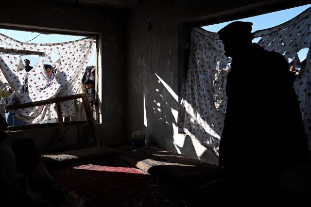 Afghan men inspect a damaged house at the site of an overnight Pakistan airstrike, at a residential area in Pol-e-Charkhi on the outskirts of Kabul on March 13, 2026. Afghan authorities said on March 13 that Pakistan had carried out new strikes on Kabul and border provinces, killing four people in the capital. (Photo by Wakil Kohsar / AFP)