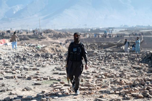 A Taliban security personnel walks past rubble at the site of an overnight Pakistan airstrike, at a residential area in Pol-e-Charkhi on the outskirts of Kabul on March 13, 2026. Afghan authorities said on March 13 that Pakistan had carried out new strikes on Kabul and border provinces, killing four people in the capital. (Photo by Wakil KOHSAR / AFP)