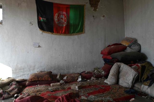 An Afghan national flag hangs on a wall inside a damaged house at the site of an overnight Pakistan airstrike, at a residential area in Pol-e-Charkhi on the outskirts of Kabul on March 13, 2026. Afghan authorities said on March 13 that Pakistan had carried out new strikes on Kabul and border provinces, killing four people in the capital. (Photo by Wakil KOHSAR / AFP)