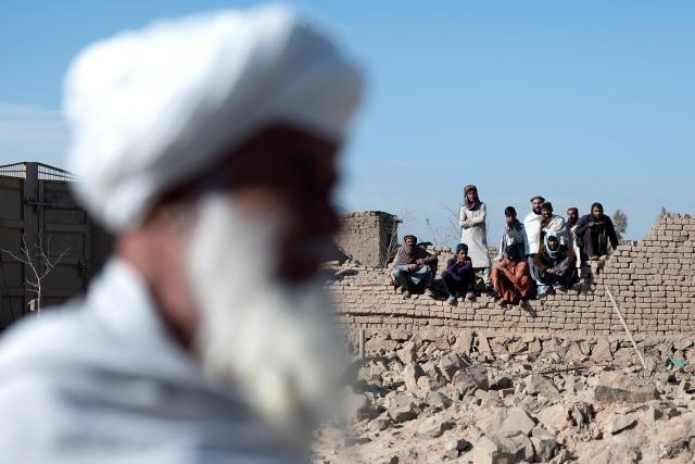 Afghans sit amidst damaged houses at the site of an overnight Pakistan airstrike, at a residential area in Pol-e-Charkhi on the outskirts of Kabul on March 13, 2026. Afghan authorities said on March 13 that Pakistan had carried out new strikes on Kabul and border provinces, killing four people in the capital. (Photo by Wakil KOHSAR / AFP)