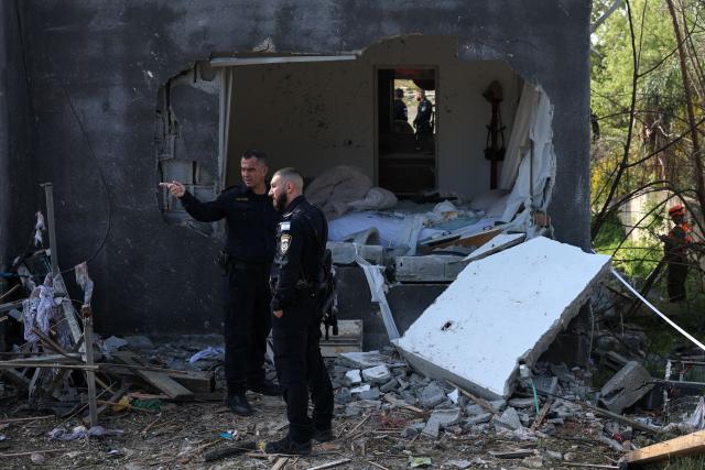 TOPSHOT - Israeli policemen inspect the site of a rocket strike in Zarzir, northern Israel, on March 13, 2026. New waves of attacks struck Iran and Gulf nations on March 13 after Tehran renewed its threats on oil facilities, while France announced its first soldier killed during the Mideast war. The latest strikes on Iran hit over 200 targets in the past day, Israel's military said well into the second week of the US-Israeli campaign that has grown into a deadly regional fight causing economic chaos. (Photo by Odd ANDERSEN / AFP) / 