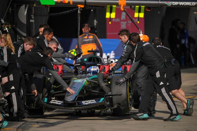 Mechanics push the car of Mercedes' British driver George Russell in the pits during the sprint qualifying session ahead of the Formula One Chinese Grand Prix at the Shanghai International Circuit in Shanghai on March 13, 2026. (Photo by Andy WONG / POOL / AFP)