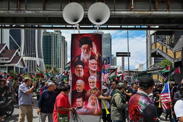 Protestors shows portraits of Iran's slain supreme leader Ayatollah Ali Khamenei and others killed during US and Israeli strikes on Iran during a demonstration to mark al-Quds (Jerusalem) Day, after Friday prayers in Kuala Lumpur on March 13, 2026. (Photo by Mohd Rasfan / AFP)