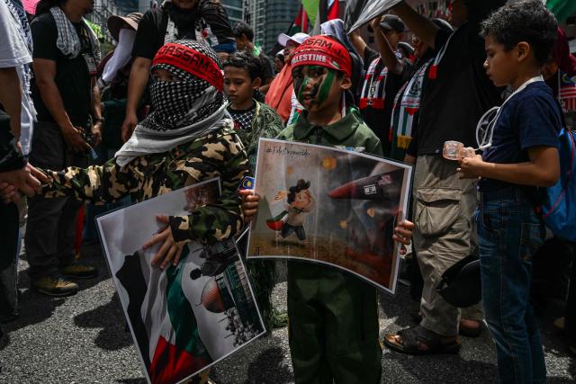 Children hold placards during a demonstration to mark al-Quds (Jerusalem) Day, after Friday prayers in Kuala Lumpur on March 13, 2026. (Photo by Mohd Rasfan / AFP)