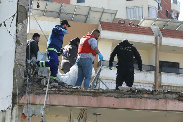 First aid responders evacuate a body from the site of an Israeli airstrike that targeted a neighborhood in the town of Mieh Mieh, some five kilometers east of the southern Lebanese city of Sidon on March 13, 2026. Israel continued striking Beirut as it threatened to expand operations and seize territory in Lebanon if the militant group Hezbollah did not stop its attacks. (Photo by MAHMOUD ZAYYAT / AFP)