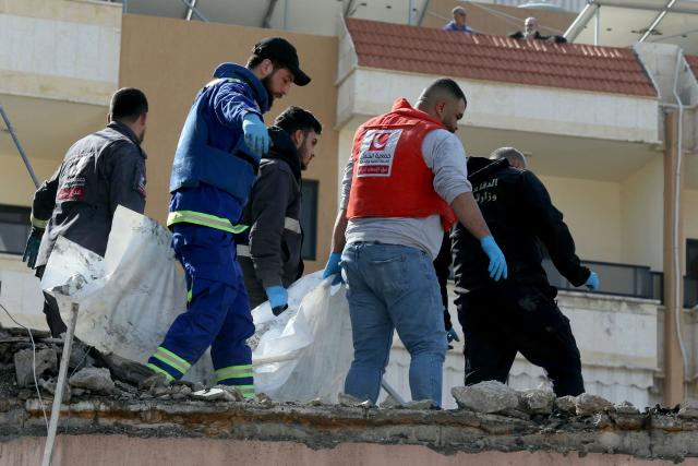 First aid responders evacuate a body from the site of an Israeli airstrike that targeted a neighborhood in the town of Mieh Mieh, some five kilometers east of the southern Lebanese city of Sidon on March 13, 2026. Israel continued striking Beirut as it threatened to expand operations and seize territory in Lebanon if the militant group Hezbollah did not stop its attacks. (Photo by MAHMOUD ZAYYAT / AFP)
