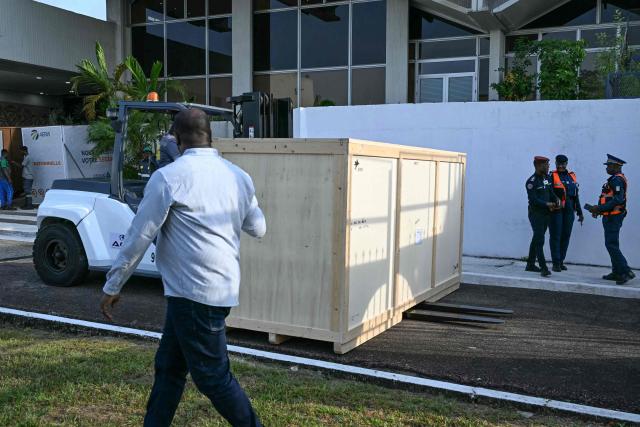A crate containing the Djidji Ayokwe drum, also known as the talking drum, that was looted by French colonial troops from Ivory Coast in 1916, arrives during the latest repatriation of stolen artefacts at the Félix Houphouët-Boigny International Airport in Abidjan on March 13, 2026. The Djidji Ayokwe drum, more than three metres (10 feet) long and weighing 430 kilos (950 pounds) was used by the Ebrie tribe to transmit messages.
It is one of hundreds of objects France is sending back to Africa.
France has been flooded with restitution demands from former colonies such as Algeria, Mali and Benin.
Its national museums hold tens of thousands of artworks and other prized artefacts that were seized or purchased during the colonial era. (Photo by Issouf SANOGO / AFP)